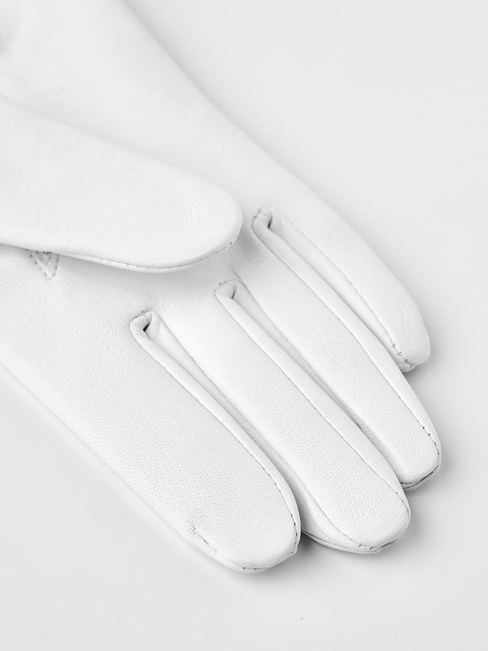 White machine-sewn leather glove with button
 (2 of 5)