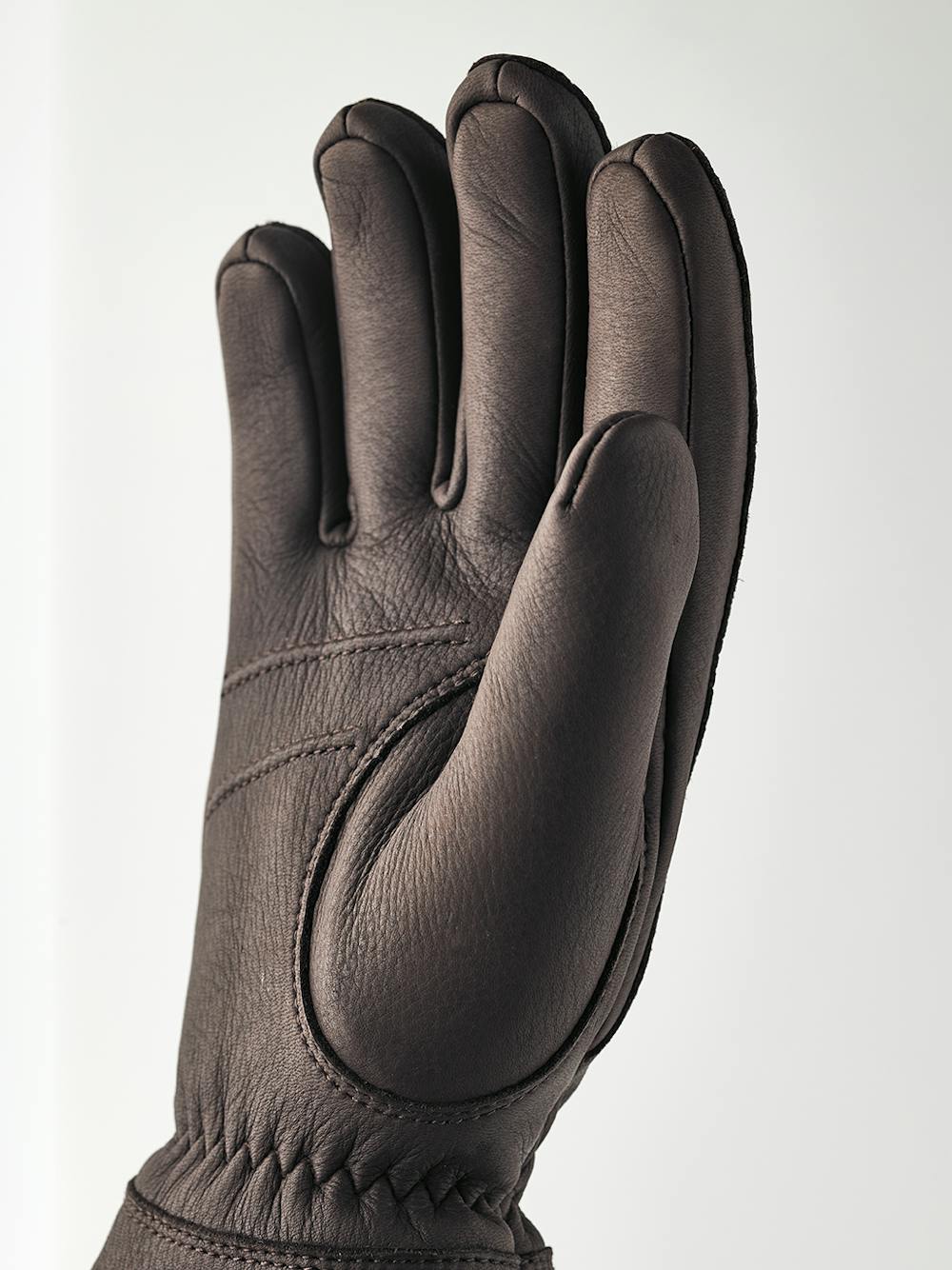 Dark brown machine-sewn deerskin glove with white trim
(2 of 4)