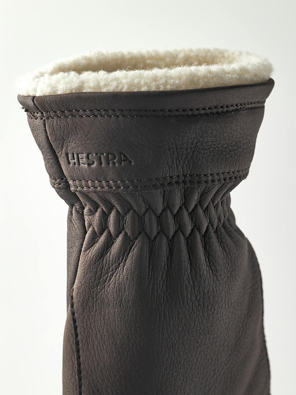 Dark brown machine-sewn deerskin glove with white trim
(3 of 4)