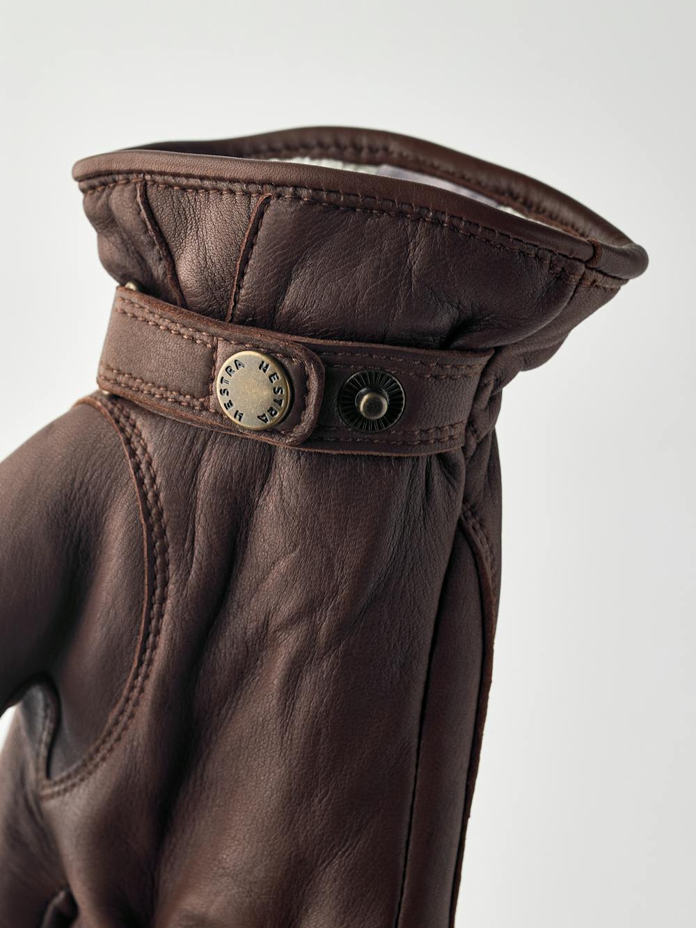 Brun maskinsydd handske i lammnappa med läderrem och knapp
(5 av 5)