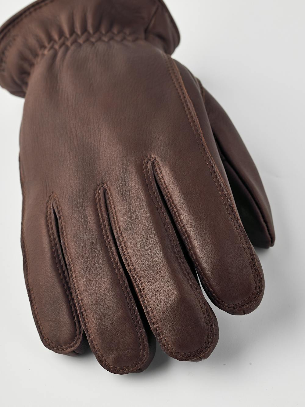 Brun maskinsydd handske i lammnappa med läderrem och knapp
(2 av 5)