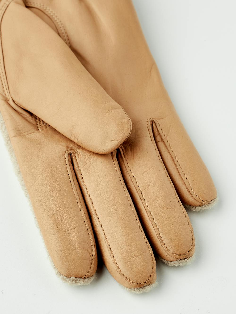 Dunkelbeiger Lederhandschuh aus Haarschafleder mit beigem Bouclé-Strick auf der Oberhand und kleiner Schleife
 (3 oder 5)