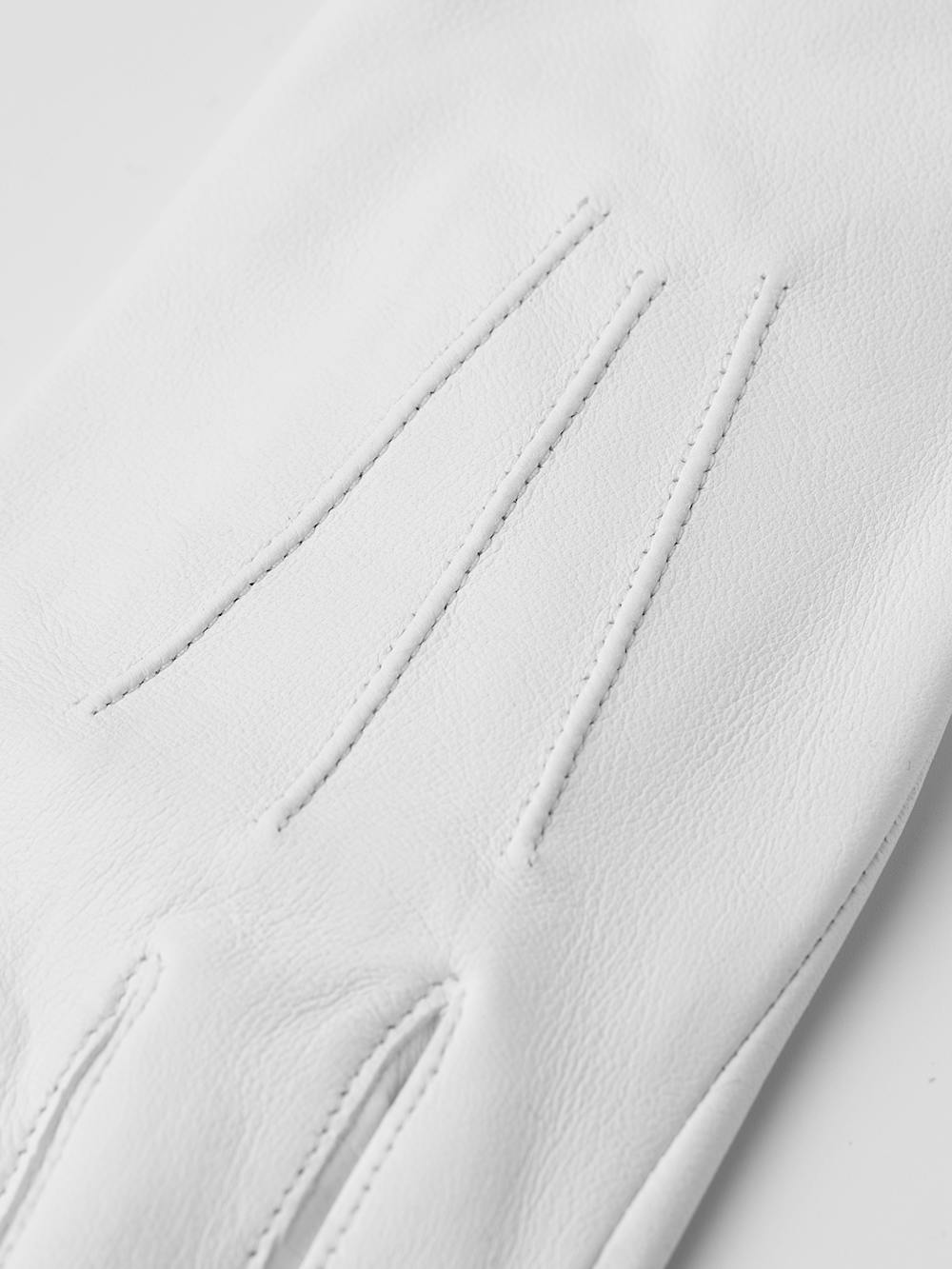 White machine-sewn hairsheep leather glove with button

 (4 of 4)