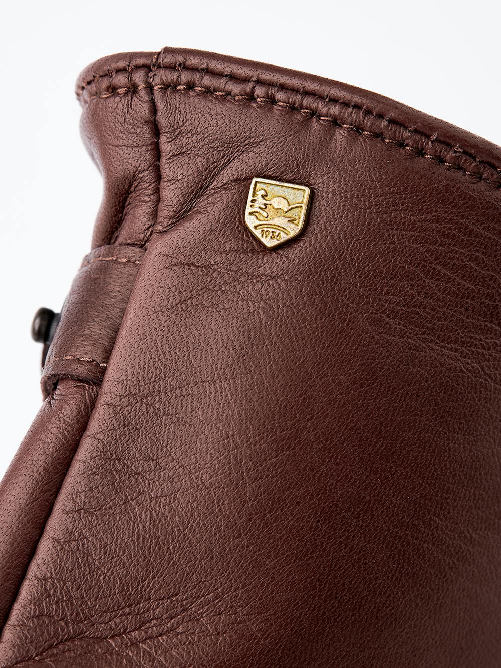 Brown machine-sewn hairsheep leather glove with leather strap
(2 of 3)