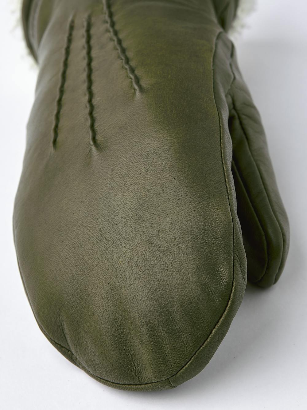 Mossgrön maskinsydd tumhandske i lammnappa med vit pälskrage
(4 av 5)