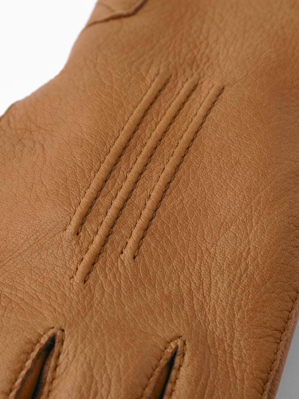 Light brown machine-sewn deerskin glove with leather strap and button
(3 of 5)