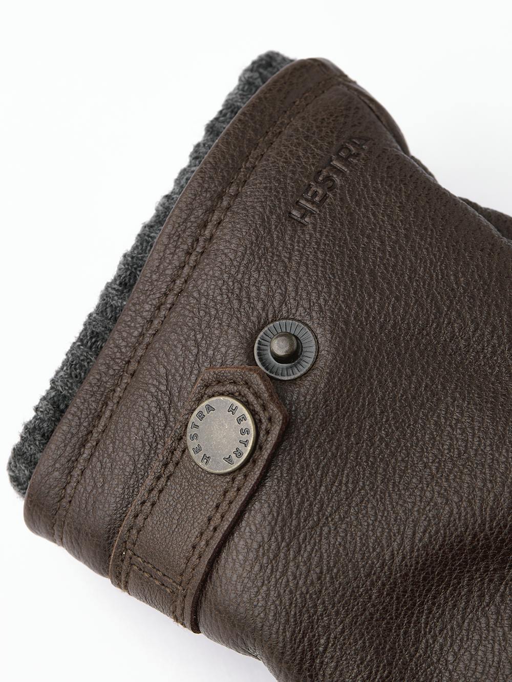 Dark brown machine-sewn elk leather glove with leather strap and button
(2 of 3)