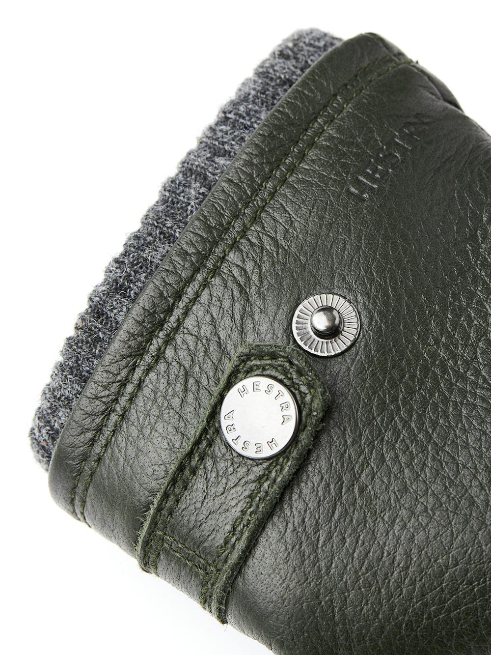 Dark green machine-sewn elk leather glove with leather strap and button
(2 of 3)