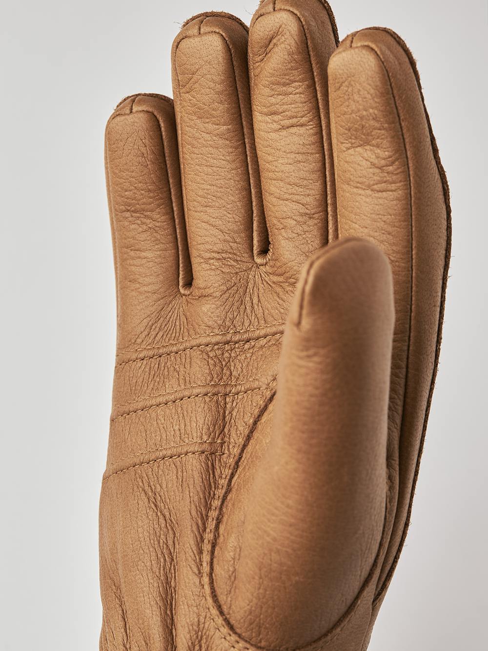 Ljusbrun maskinsydd handske i älgskinn med läderrem och knapp
(5 av 5)