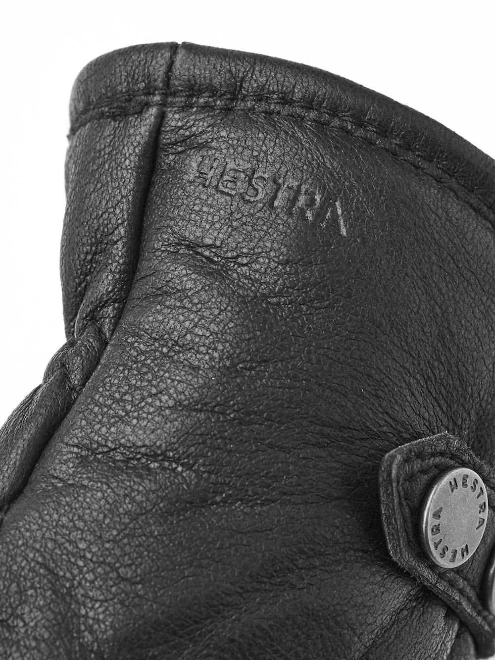 Svart maskinsydd handske i älgskinn med läderrem och knapp
(3 av 5)