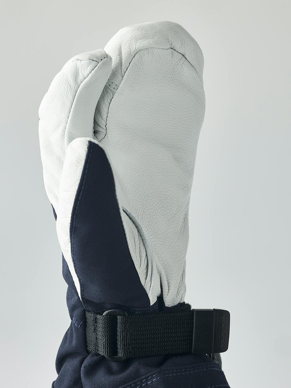 Mörkblå trefingershandske med vitt getskinn i innerhanden
(6 oder 7)