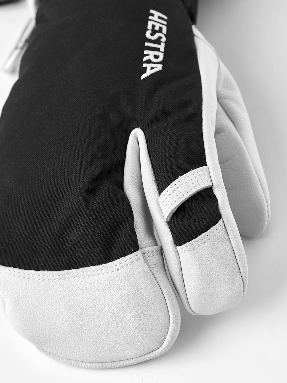 Svart trefingershandske med vitt getskinn i innerhanden
 (2 av 6)