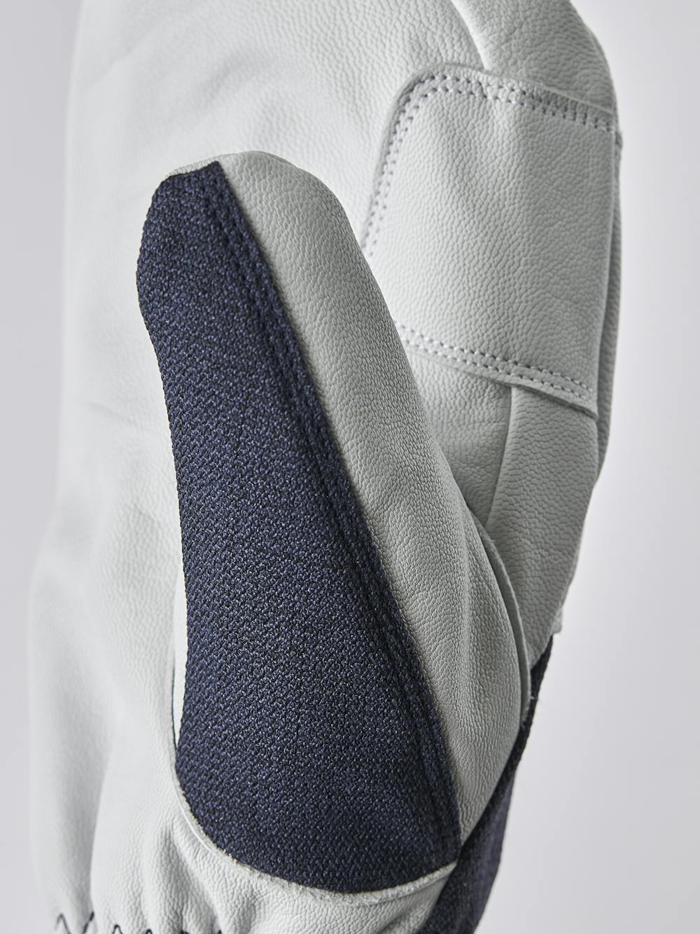 Mörkblå tumhandske med vitt getskinn i innerhanden
 (3 av 6)