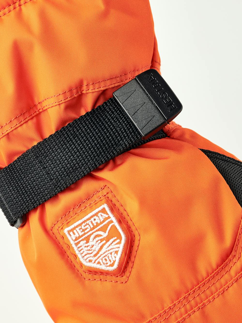 Orange barnhandske i tyg med svart innerhand i syntetmaterial och handledsjustering
 (3 av 6)