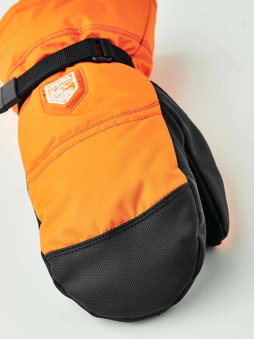 Orange tumhandske i tyg med svart innerhand i syntetmaterial och handledsjustering
 (2 av 6)