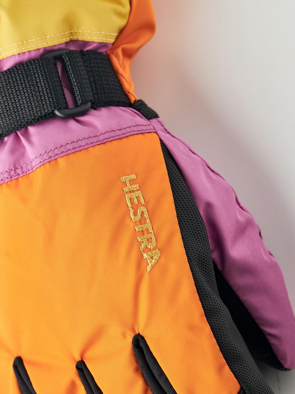 Orange und rosa Kinderhandschuh mit schwarzem Synthetikmaterial an der Innenhand und verstellbarem Handgelenkverschluss (4 oder 6)