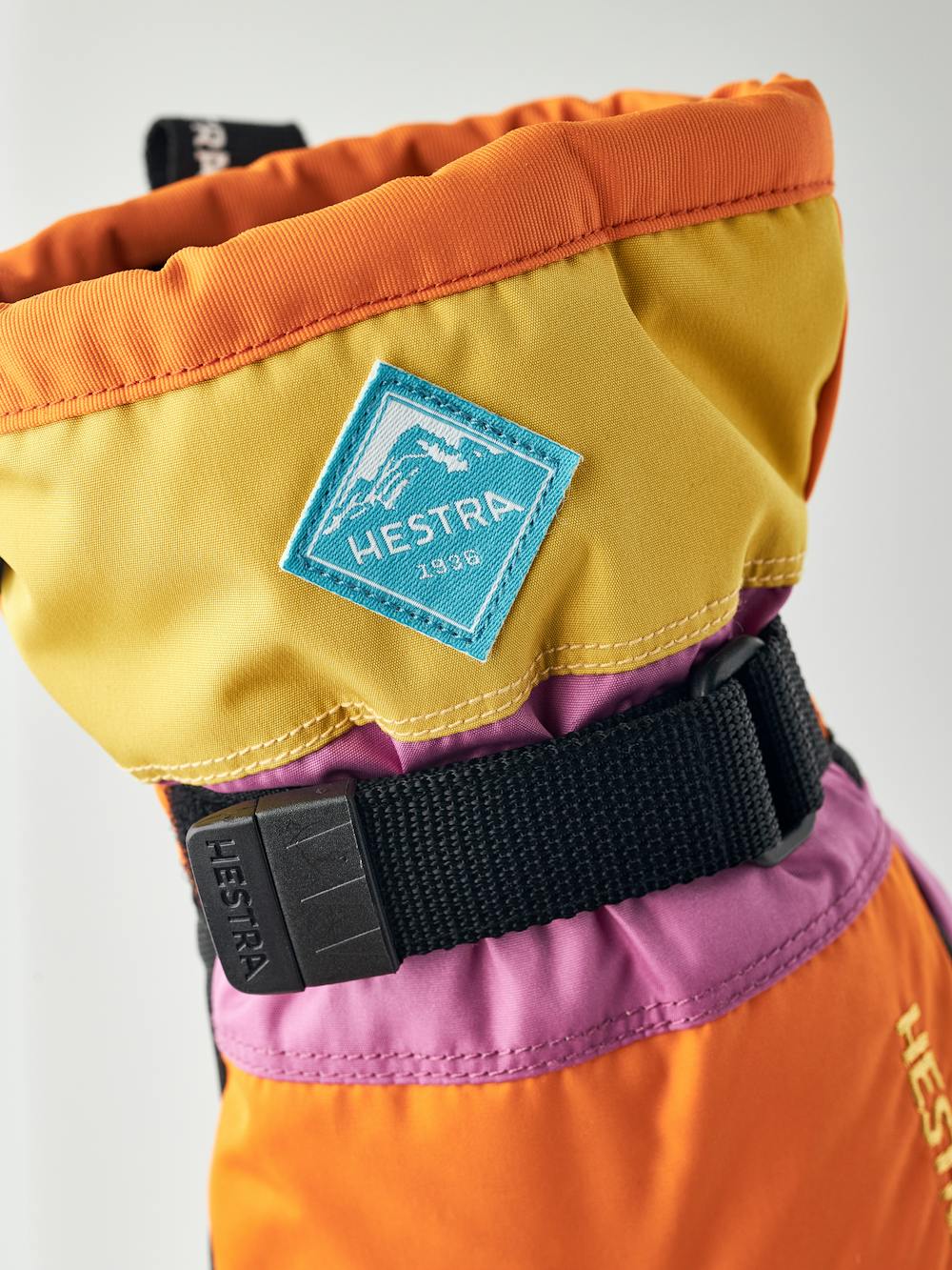 Orange und rosa Kinderhandschuh mit schwarzem Synthetikmaterial an der Innenhand und verstellbarem Handgelenkverschluss (3 oder 6)