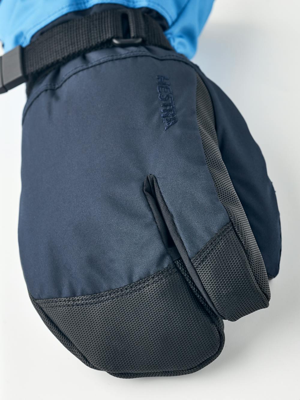 Blå trefingershandske med svart syntetmaterial i innerhanden och handledsjustering
 (2 av 5)