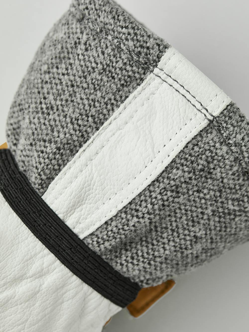 Grauer Fausthandschuh mit weißem Ziegenleder an der Innenhand und verstellbarem Handgelenkverschluss (3 oder 8)