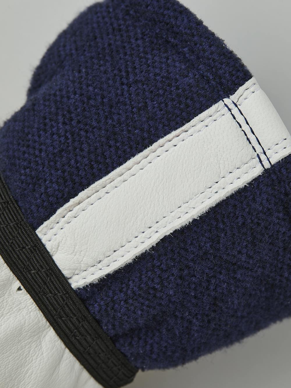 Mörkblå tumhandske med vitt getskinn i innerhanden och handledsjustering
 (3 av 5)