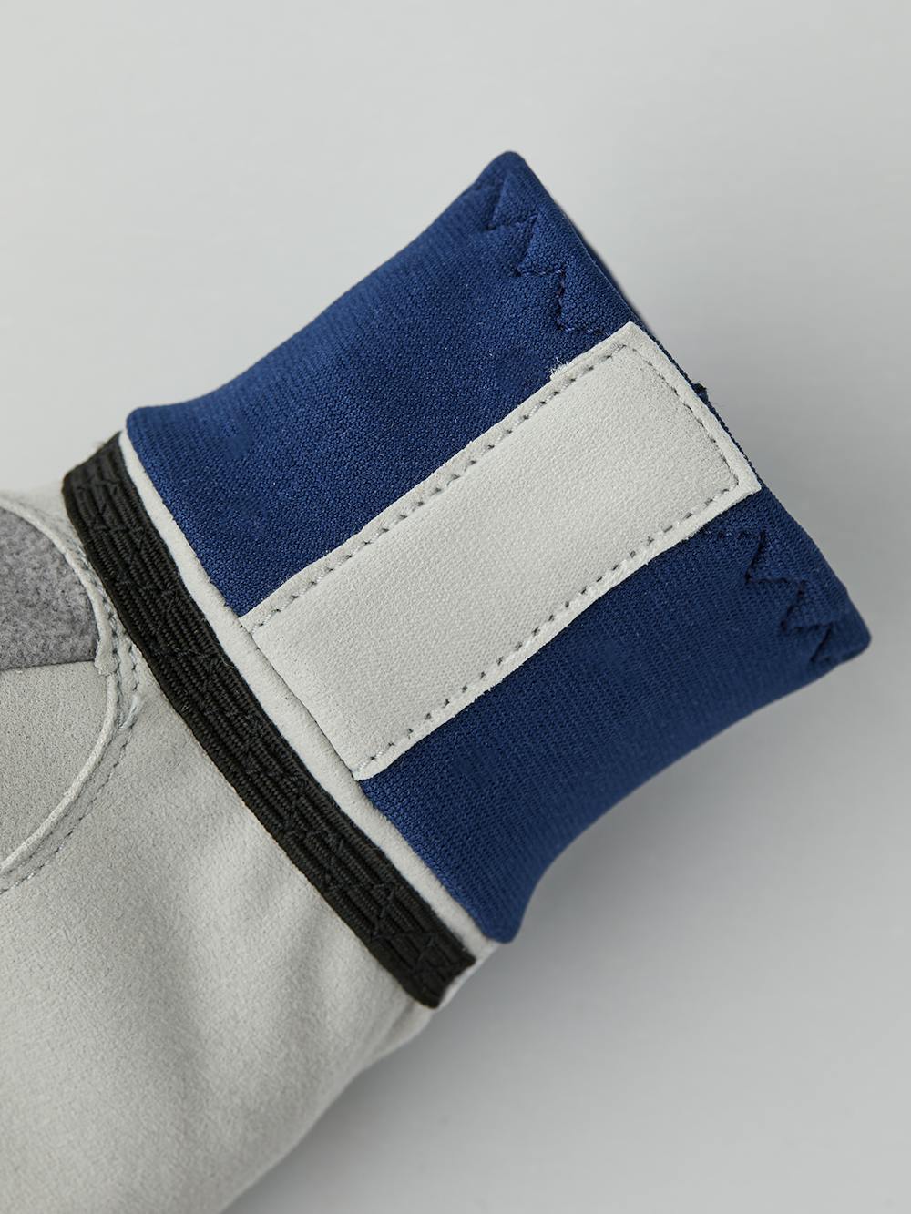 Vit och blå längdskidhandske i tyg med grå innerhand i syntetisk mocka
(3 av 5)