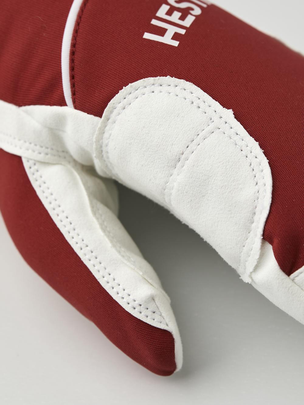 Röd tumhandske i tyg med vit innerhand i syntetisk mocka
 (5 av 6)