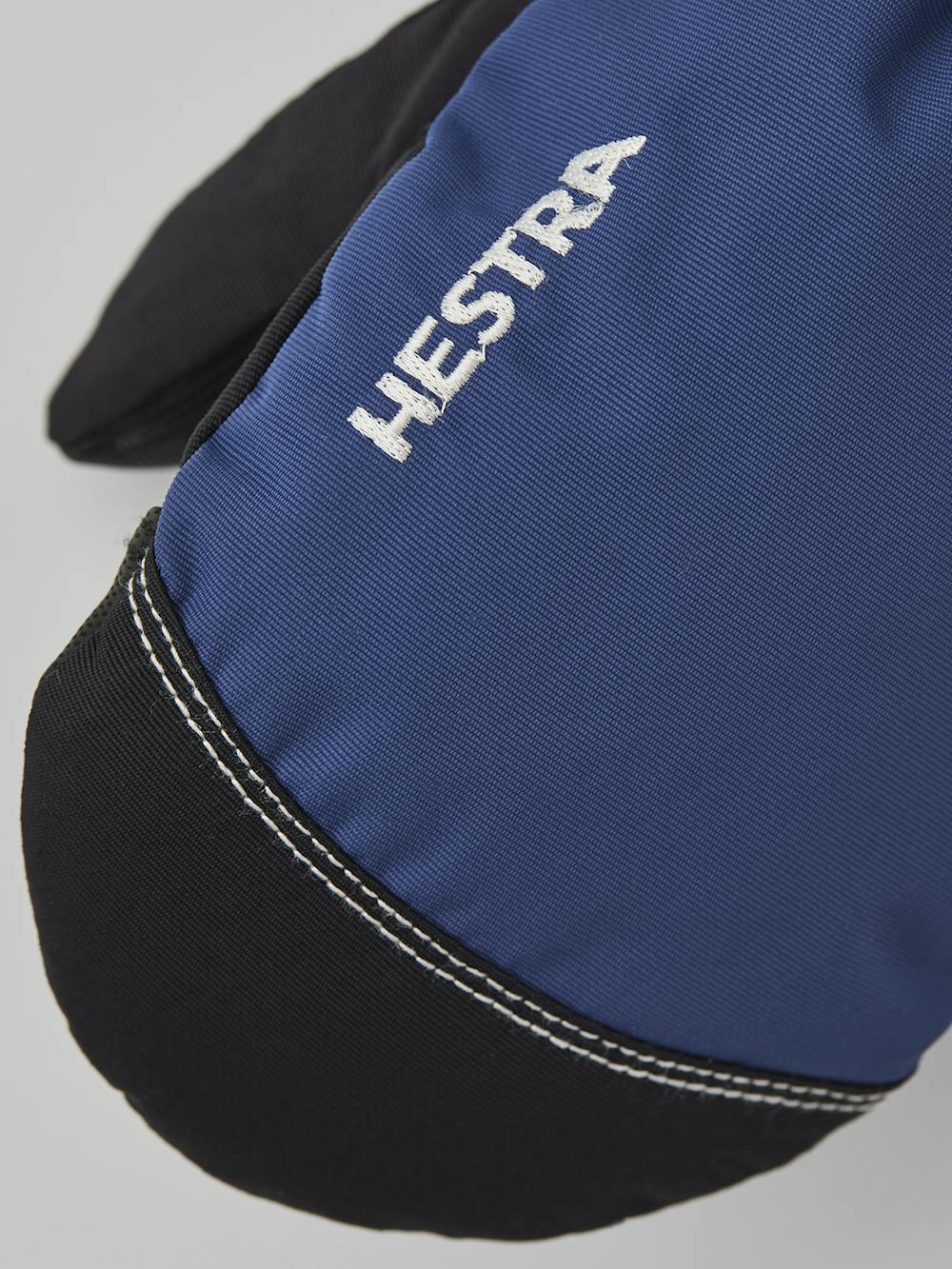 Blauer Fausthandschuh aus Stoff mit schwarzem Synthetikmaterial an der Innenhand und verstellbarem Handgelenkverschluss (2 oder 5)