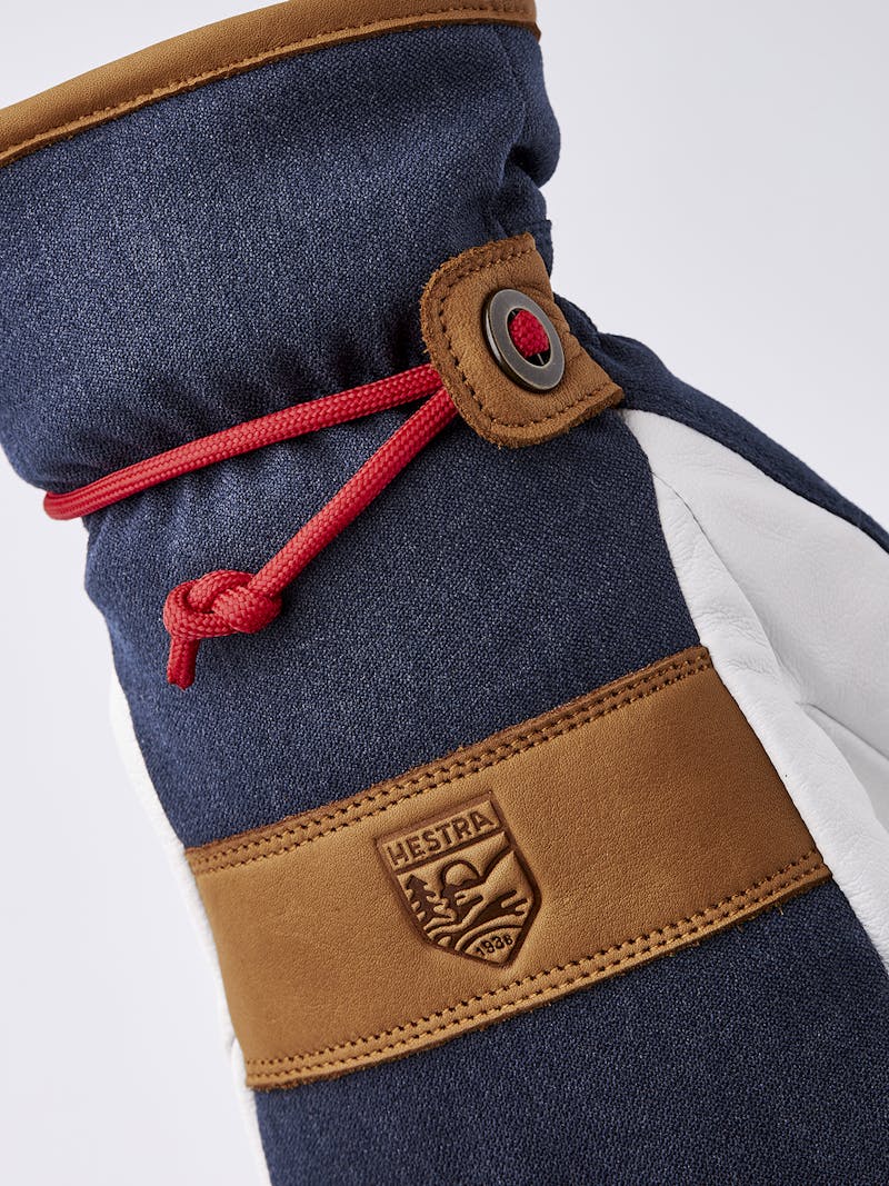 Mörkblå tumhandske med vitt getskinn i innerhanden och handledsrem
 (4 av 5)