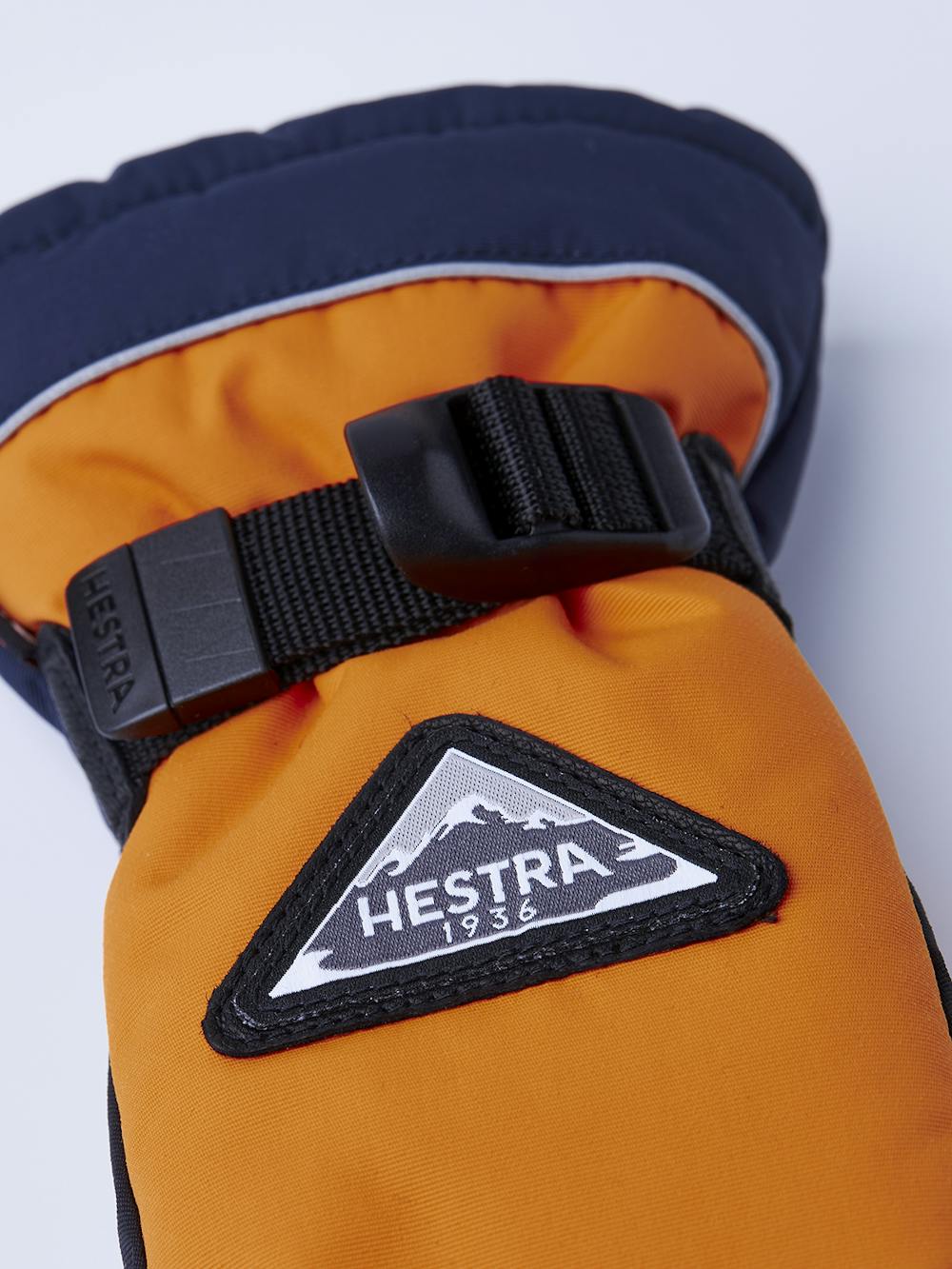 Orange tumhandske med svart getskinn i innerhanden och handledsjustering 
 (5 av 6)