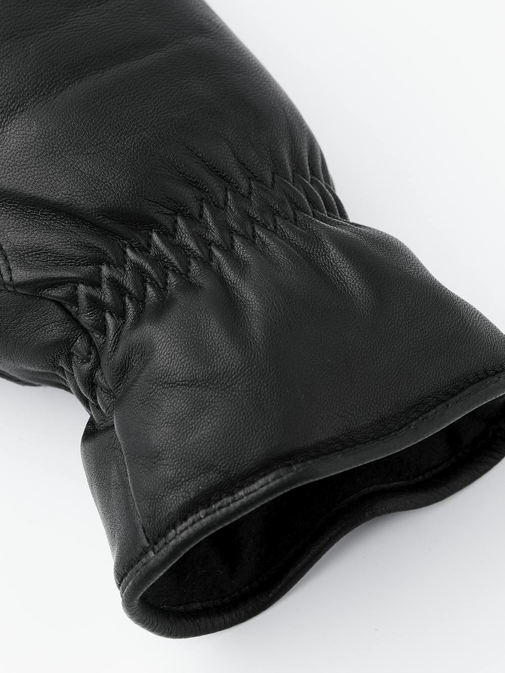 Schwarzer maschinengenähter Fausthandschuh aus Haarschafleder mit Gummizug am Handgelenk
 (3 oder 4)