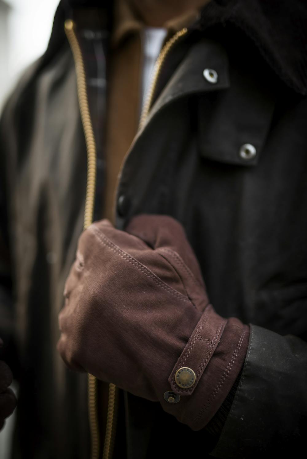 Mörkbrun maskinsydd handske i getnubuck med läderrem och knapp
(2 av 7)