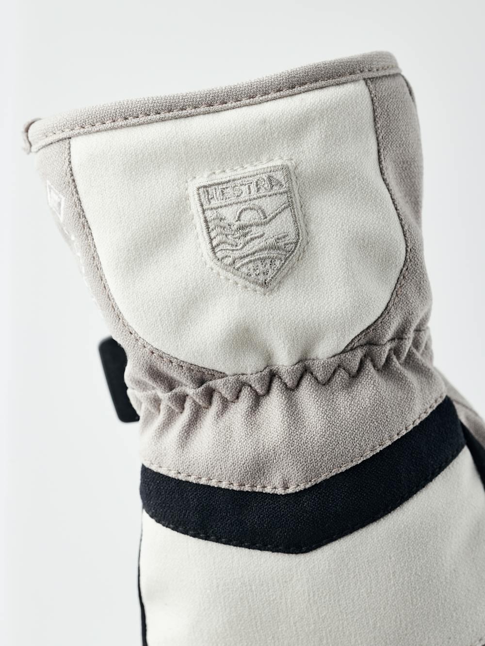 Beige and white fabric children’s glove with black synthetic palm and wrist adjustment (3 of 5)