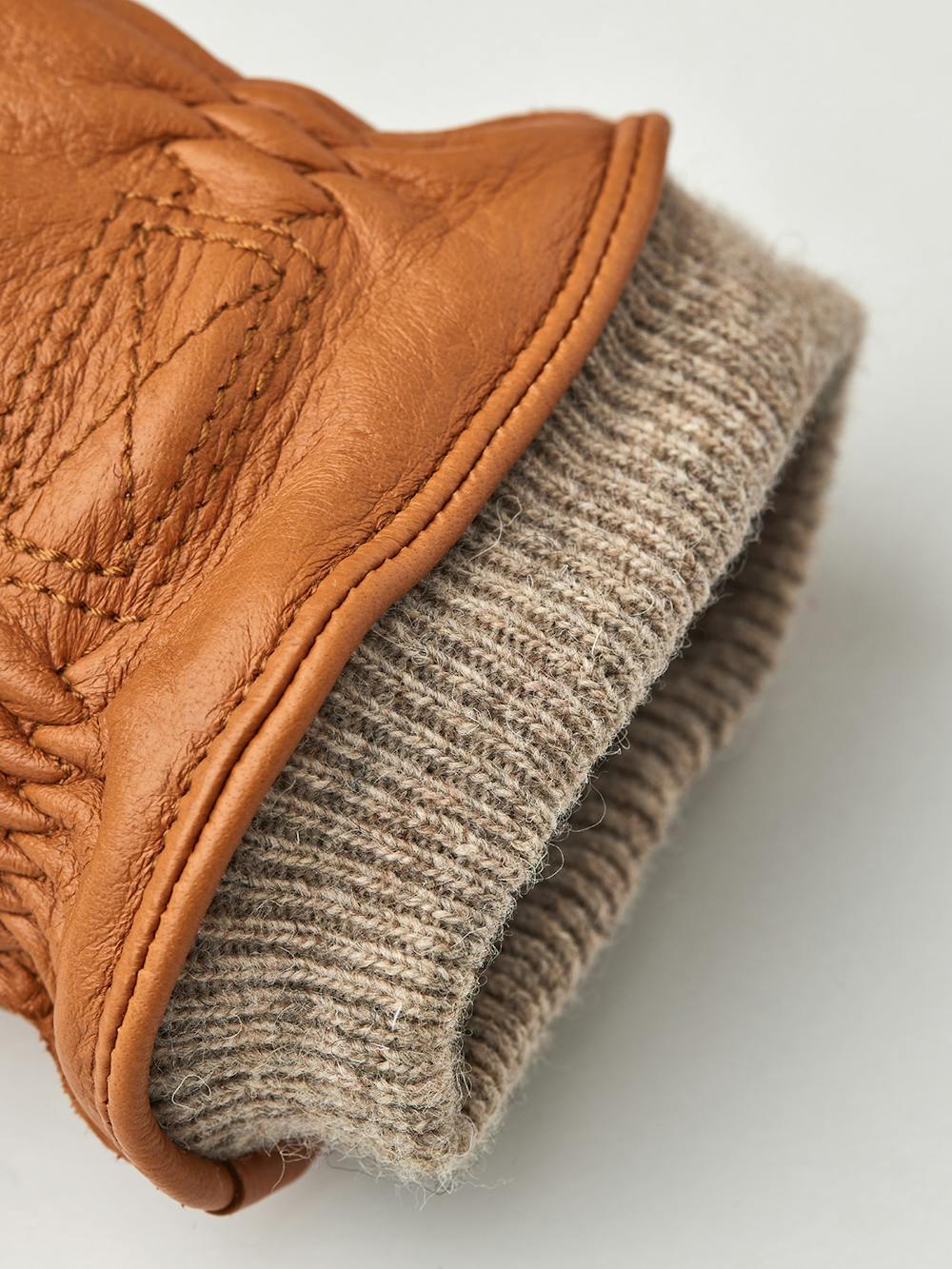 Ljusbrun maskinsydd handske i hjortskinn med beige stickad mudd
(2 av 3)